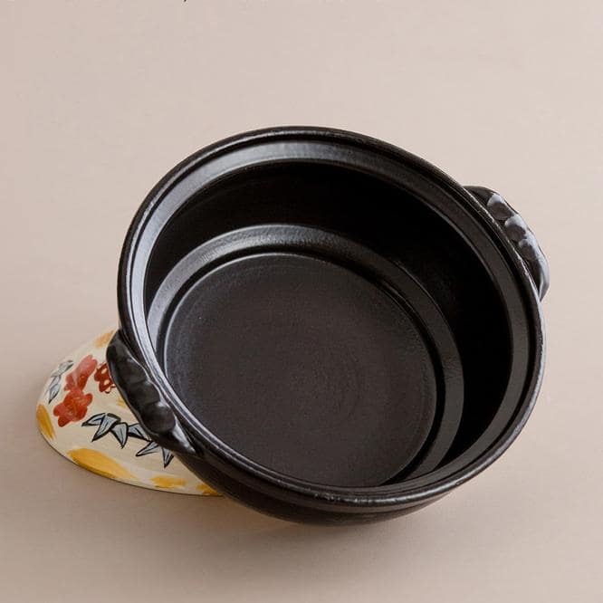 Japanese earthenware cooking pot displayed on a gas stove.