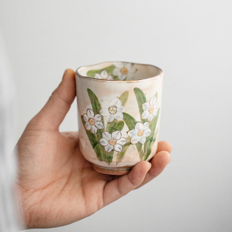 Unique hand-painted ceramic tea cup with daffodil pattern.