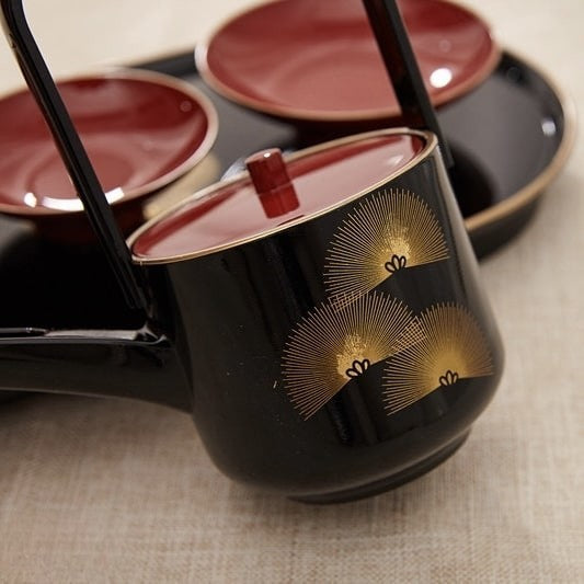 Traditional lacquered teapot and cup set with modern design.