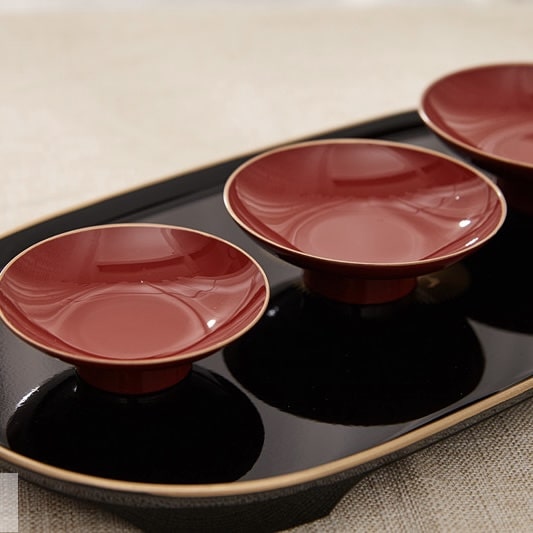 Premium tea set with golden floral patterns on a black tray.