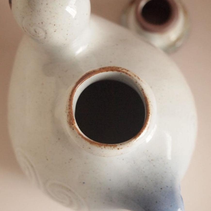 Close-up of zakka-style bird seasoning bottle on a kitchen table.