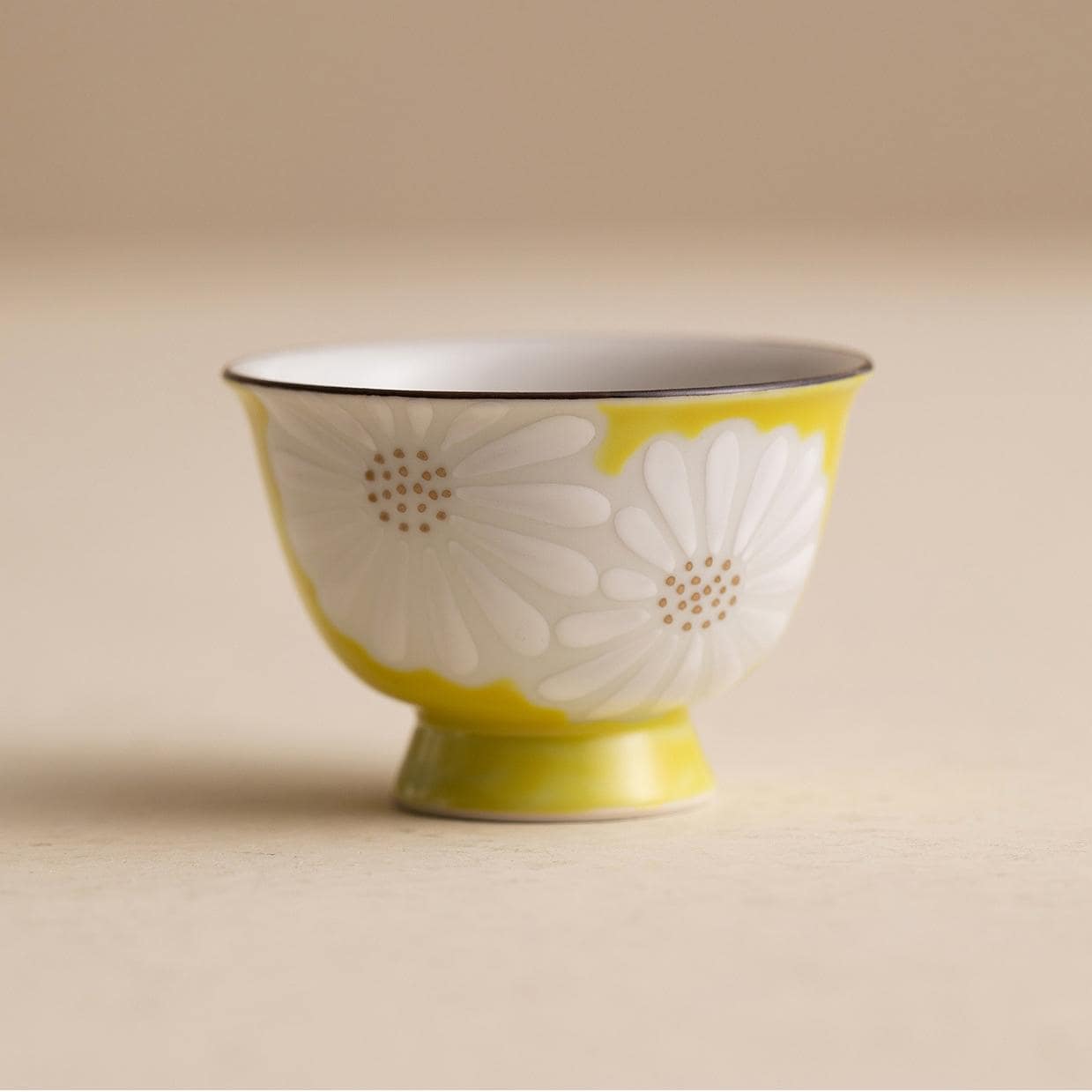 Minimalist Japanese ceramic teapot and teacup on a wooden surface.