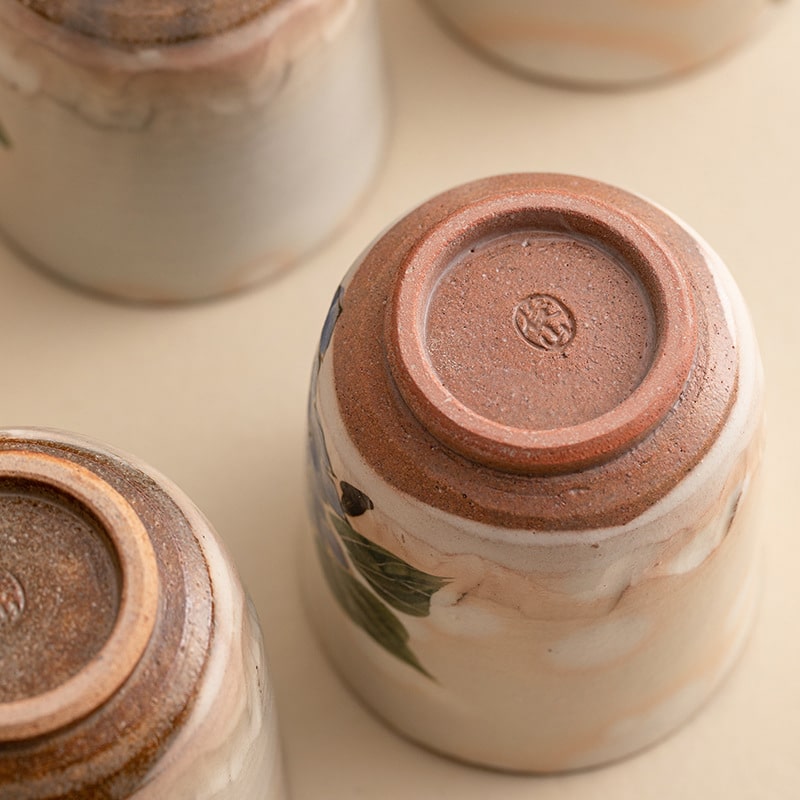 Red plum blossom ceramic tea cup with intricate detailing.