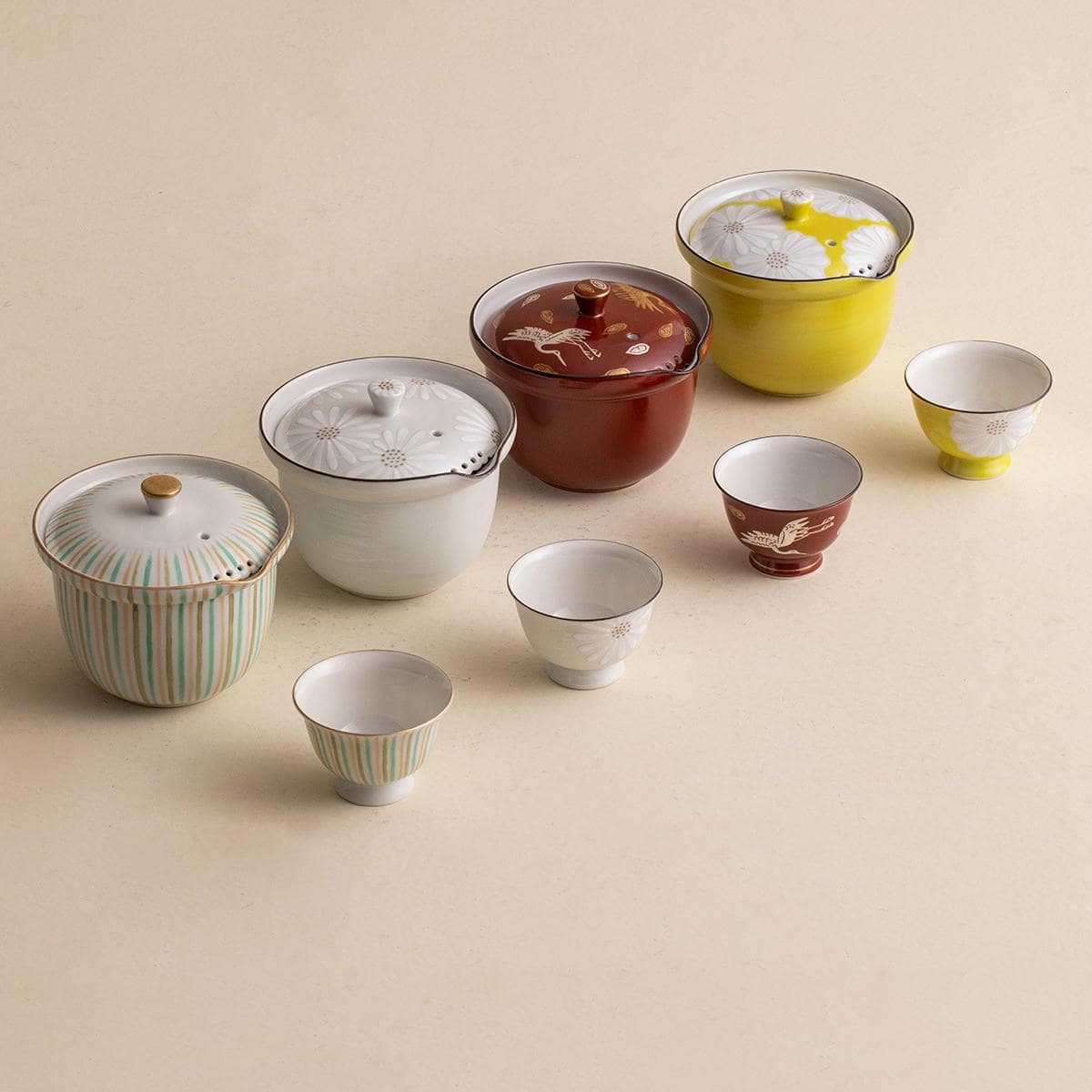 Japanese Kiyomizu-yaki teapot set displayed in a wooden shelf.