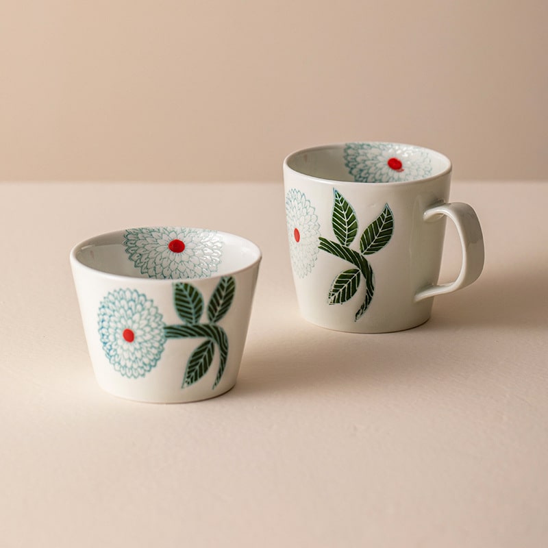 Elegant ceramic mugs with intricate floral patterns.