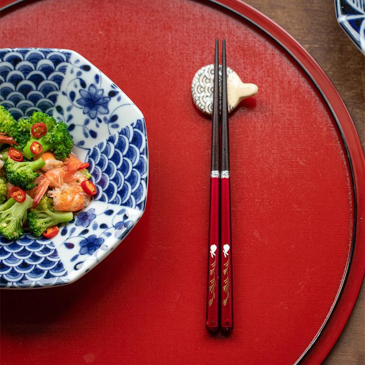 Close-up of rabbit and wheat design on handcrafted chopsticks.