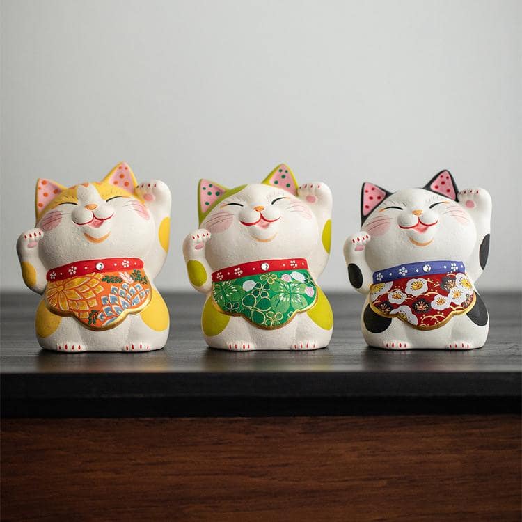 Lucky cat figurine with colorful apron on decorative mat