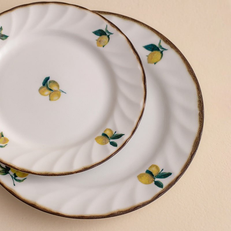 Close-up of vibrant lemon motif on ceramic dinner plates.