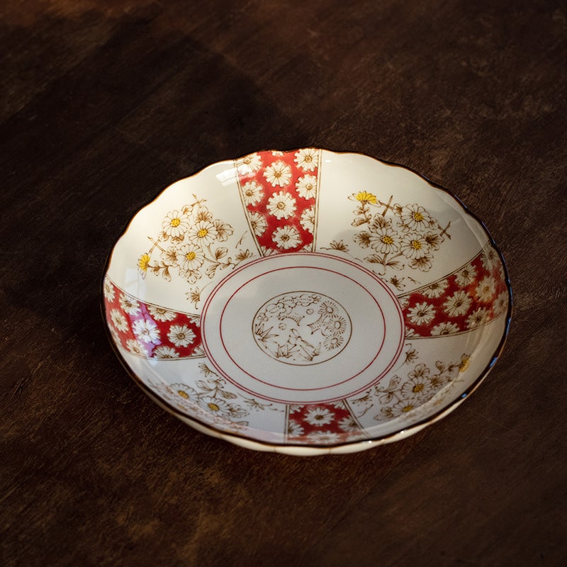 Close-up of Renfeng style tableware showcasing red and gold patterns