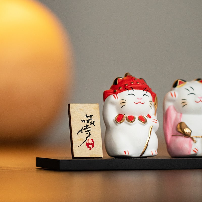 Close-up of red-dressed ceramic lucky cat figurine