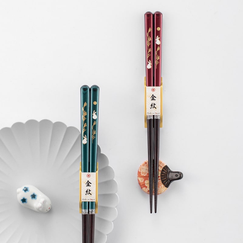 Close-up of rabbit and wheat design on handcrafted chopsticks.