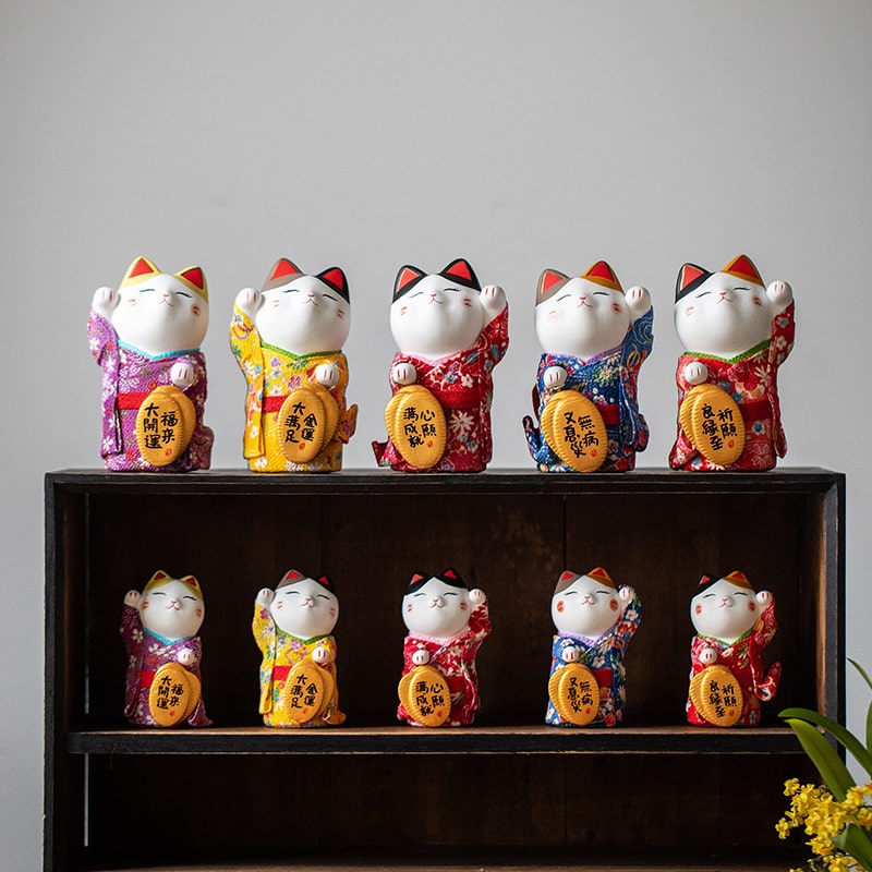 Collection of colorful Maneki Neko ceramic ornaments in traditional kimonos.