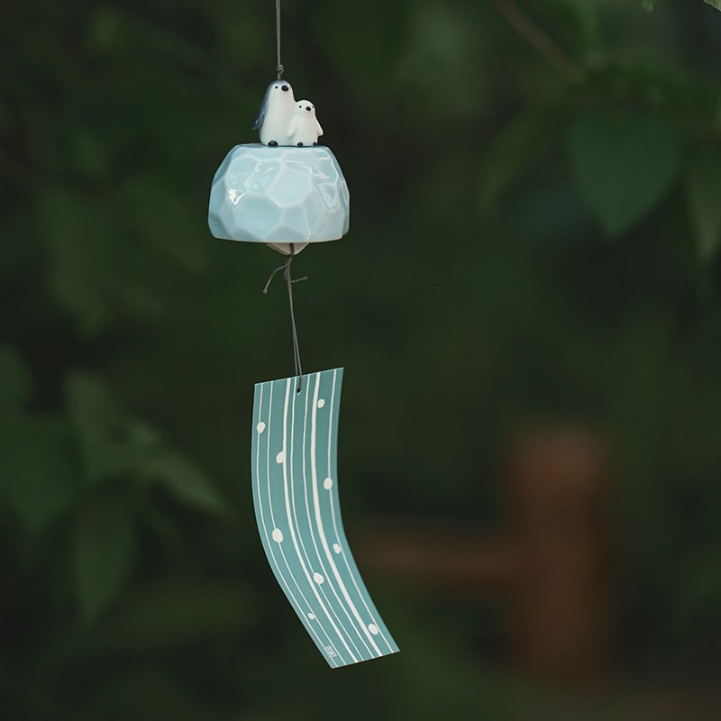 Penguin-themed Japanese wind chime hanging outdoors.