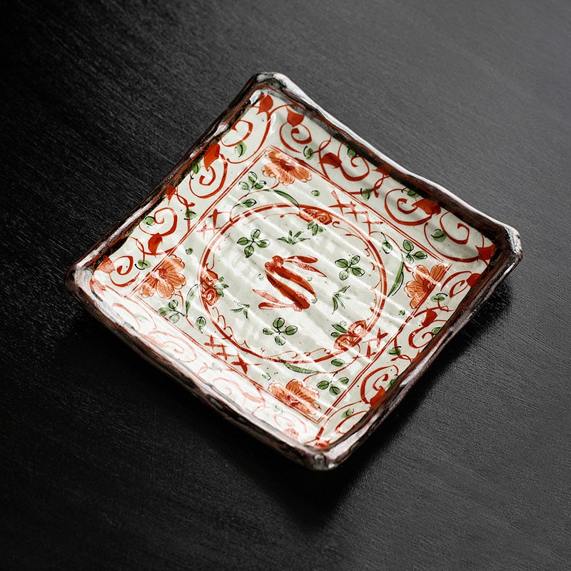 Handmade Japanese Mino ware ceramic plate with red floral design.