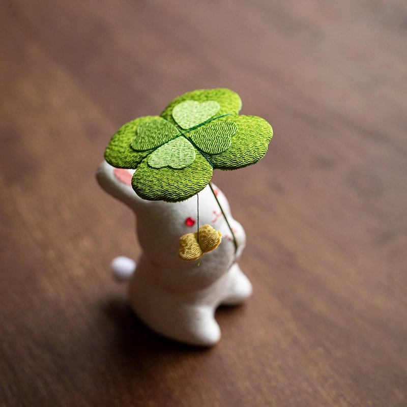 Ceramic rabbit holding a green clover umbrella, Longhutang series.