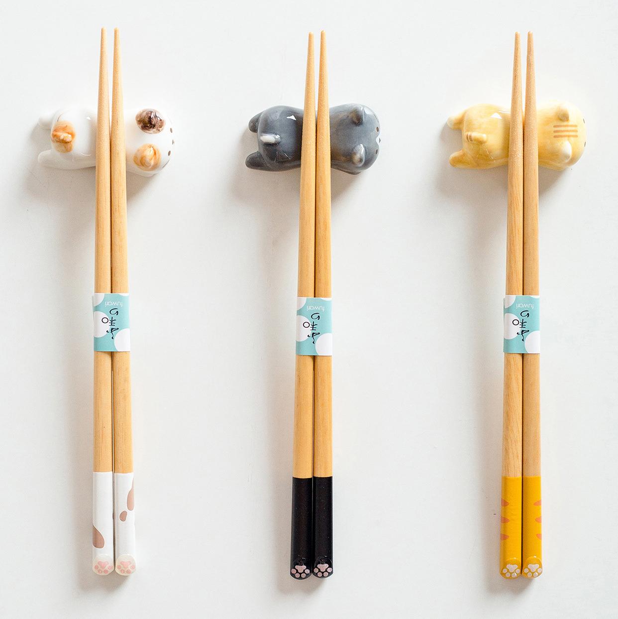 Playful cat-themed chopsticks resting on ceramic holders