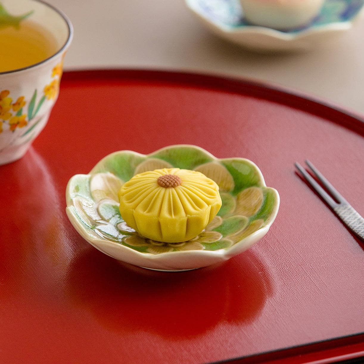 Elegant small Japanese floral dessert and dipping plates on a red tray