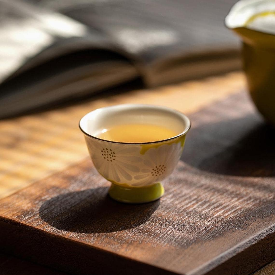 Close-up of floral-patterned Kiyomizu-yaki teacup in white and yellow.