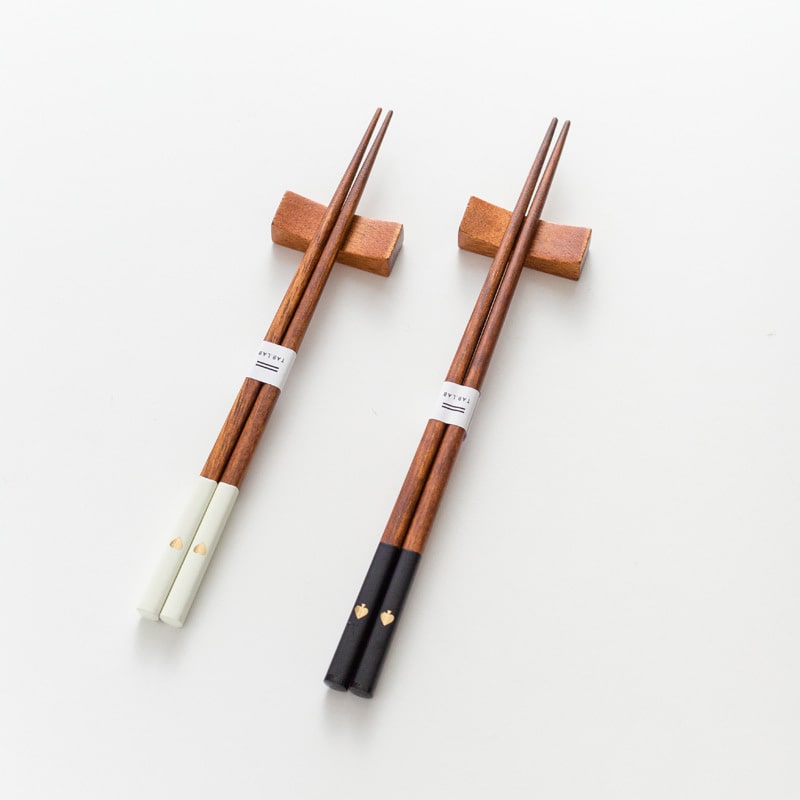 Wooden chopsticks with gold heart details and a matching rest