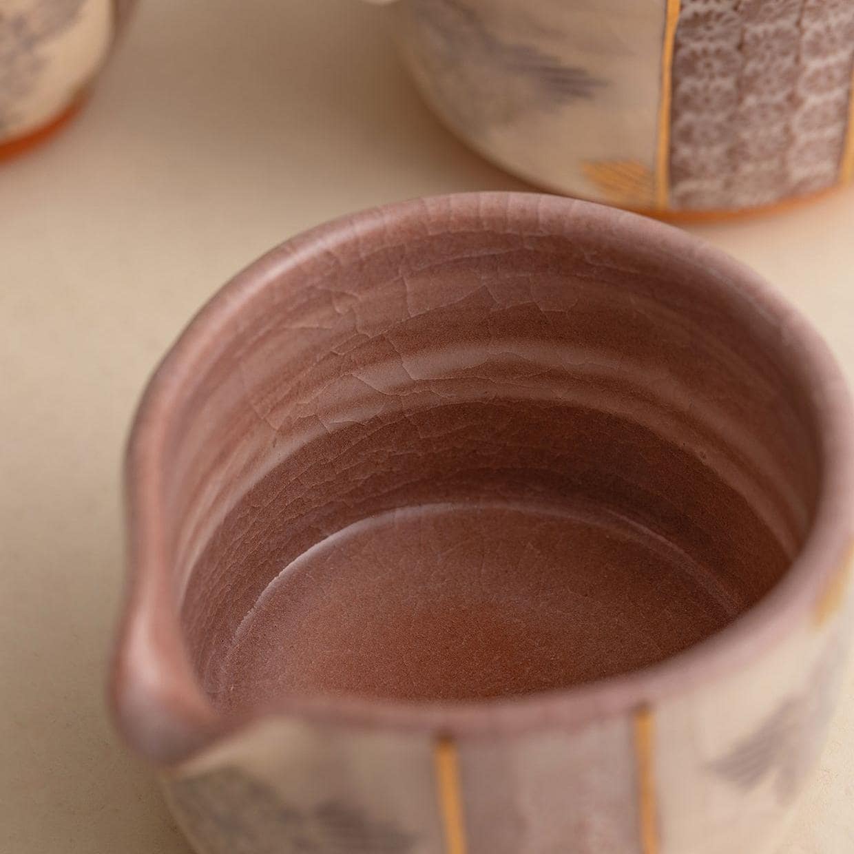 Handcrafted Japanese Kiyomizu-yaki teapot and cup on a wooden tray.