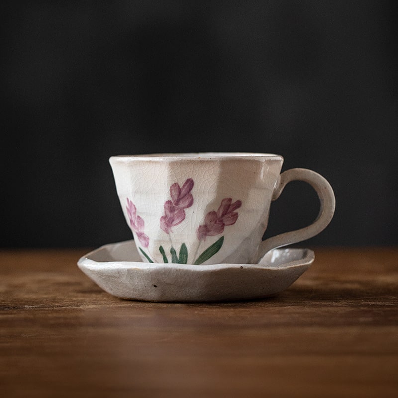 Hand-painted ceramic cup with lavender design and saucer.