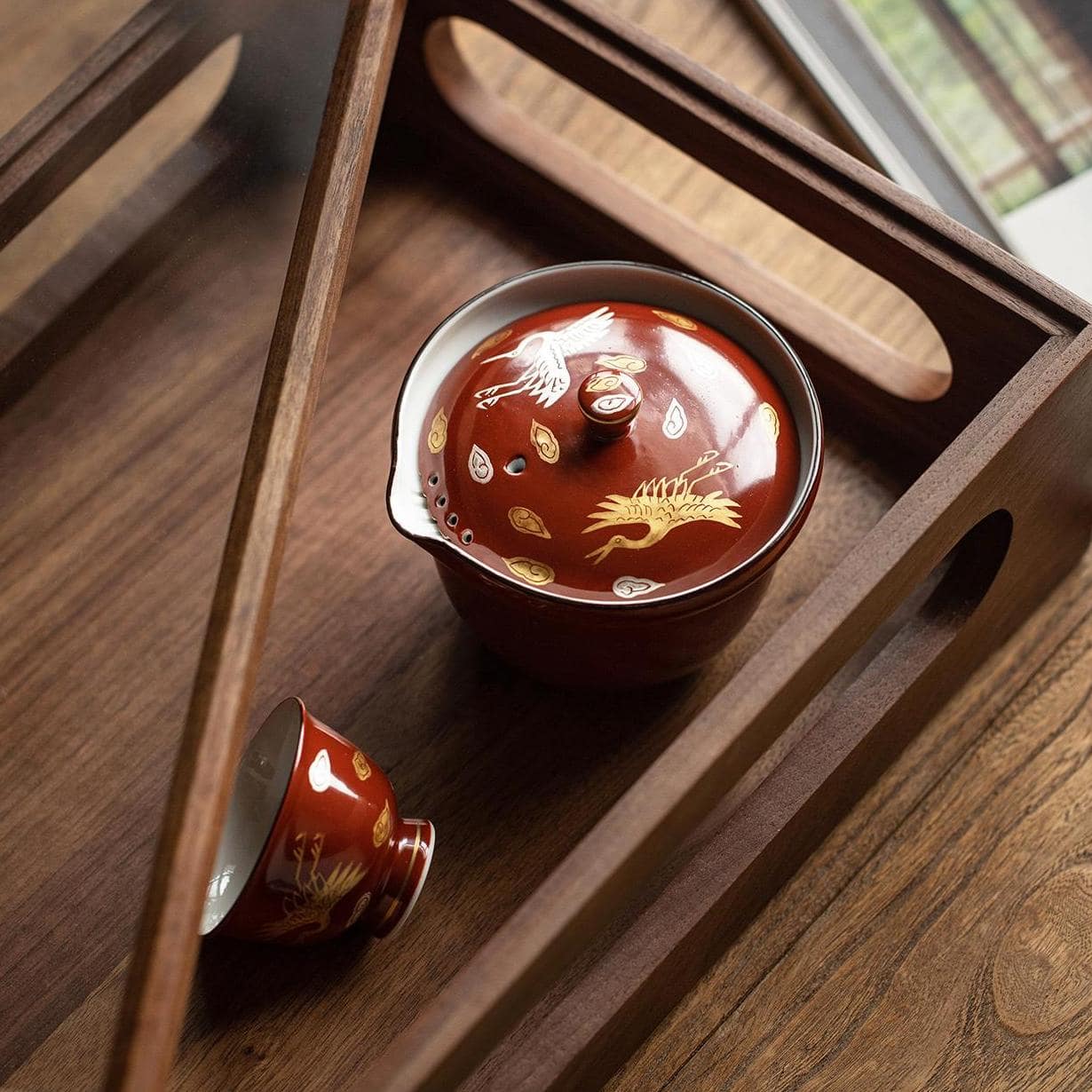 Minimalist Japanese ceramic teapot and teacup on a wooden surface.