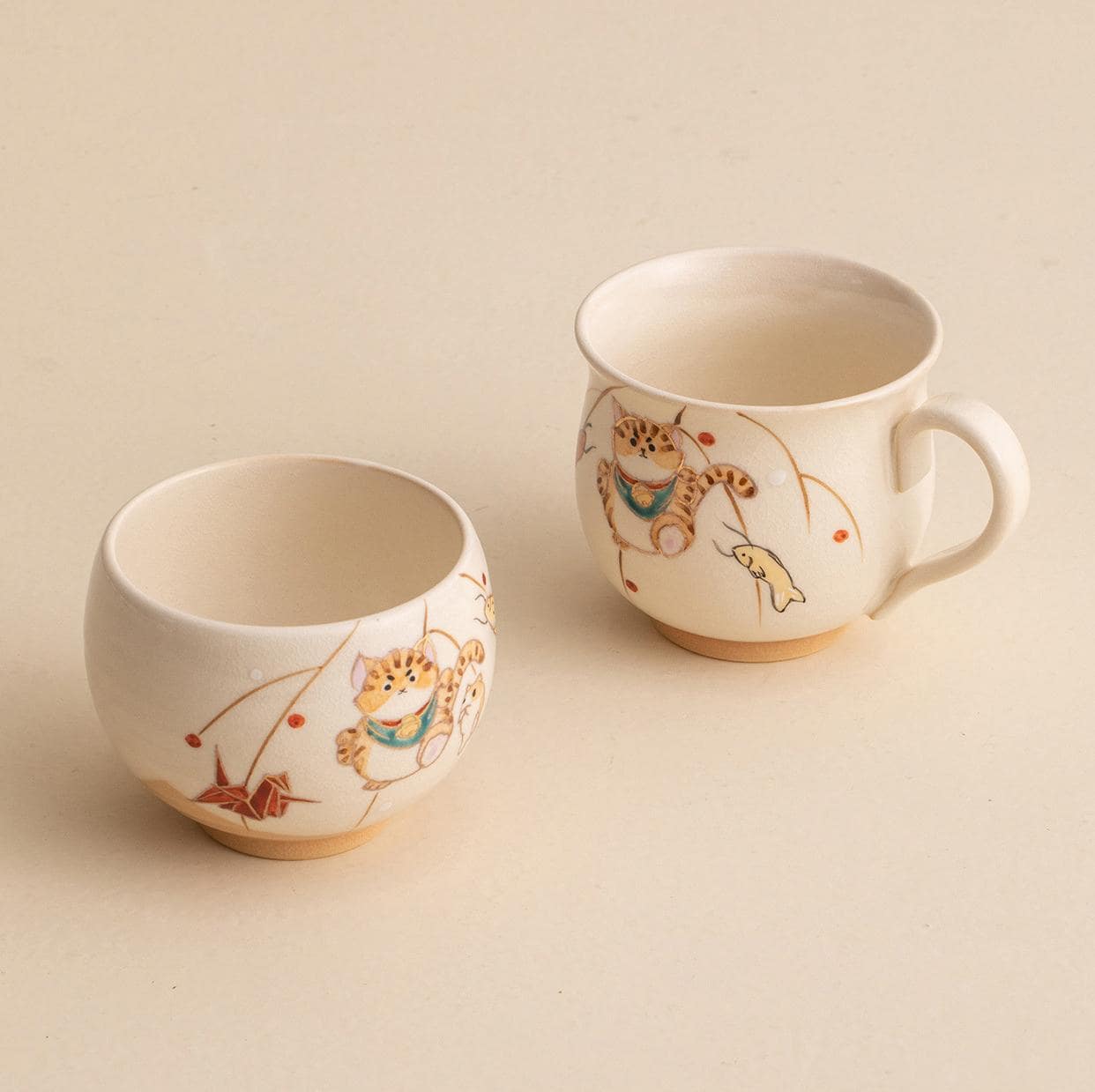 Collection of hand-painted ceramic cups with whimsical designs on a wooden shelf.