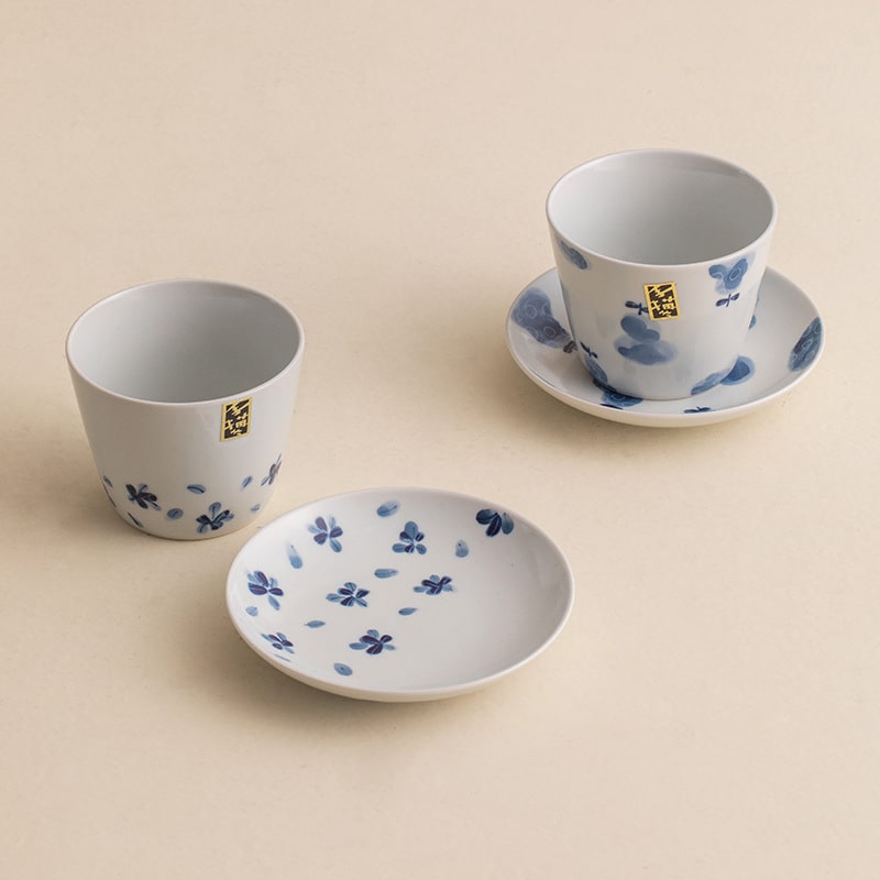 Hand holding Blue Floral Porcelain Cup filled with tea