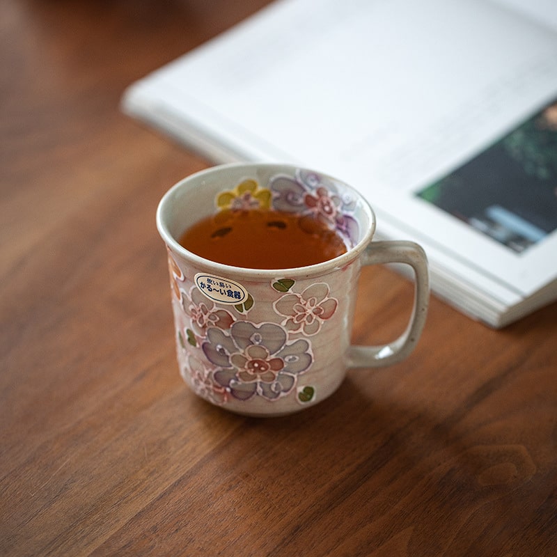 Close-up of ceramic mug showcasing hand-painted flowers