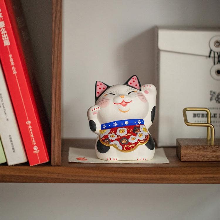 Lucky cat figurine with colorful apron on decorative mat