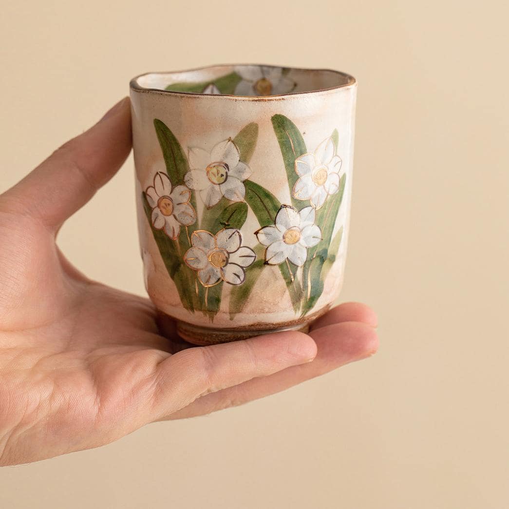 Unique hand-painted ceramic tea cup with daffodil pattern.