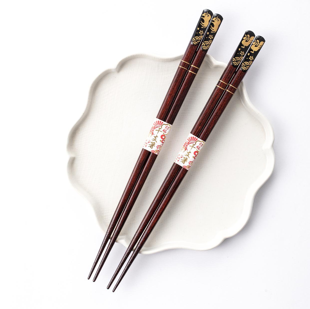 Close-up of elegant wooden chopsticks with gold patterns