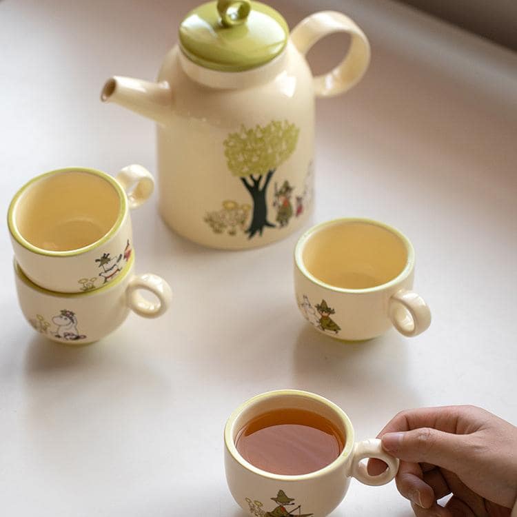 Close-up of green Moomin teapot lid with detailed craftsmanship.