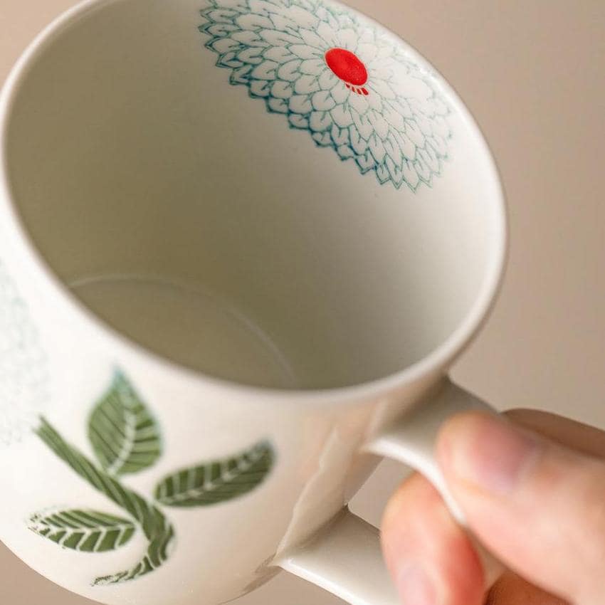 Elegant ceramic mugs with intricate floral patterns.