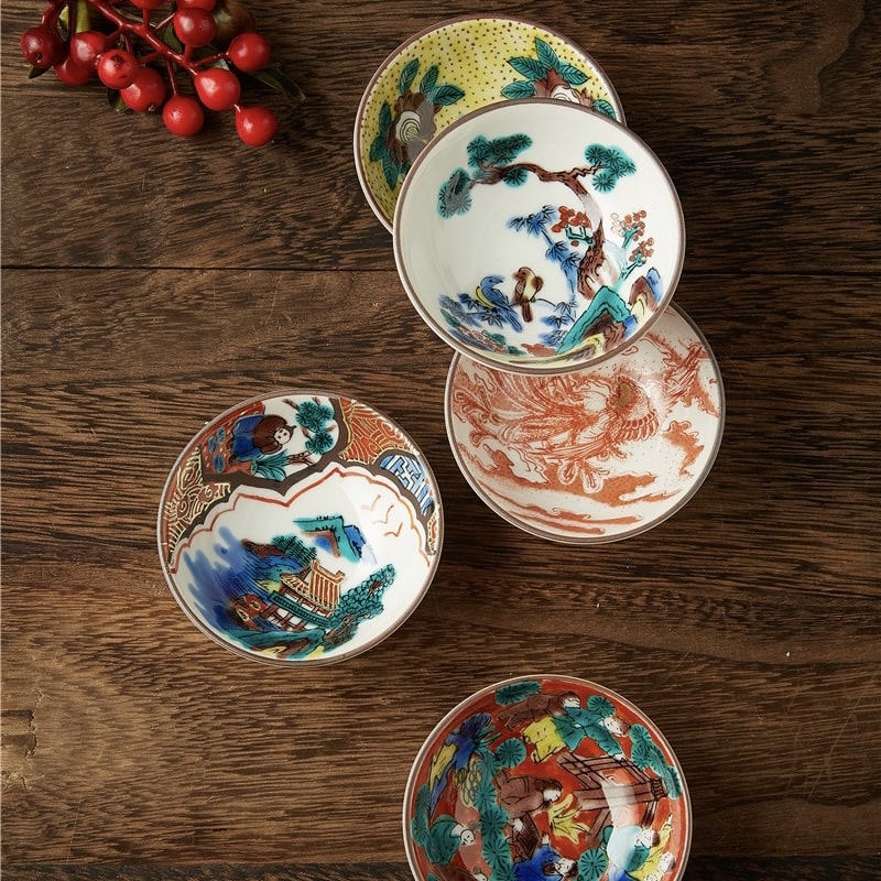 Japanese tea cup set with hand-painted designs in a wooden box.
