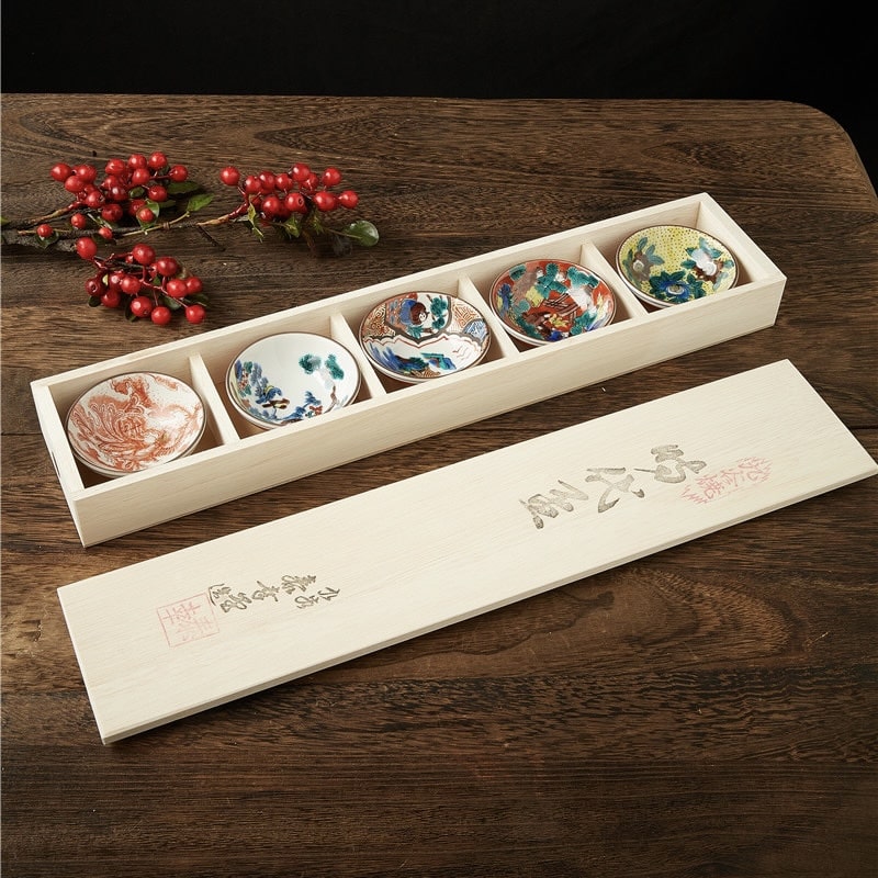 Japanese tea cup set with hand-painted designs in a wooden box.
