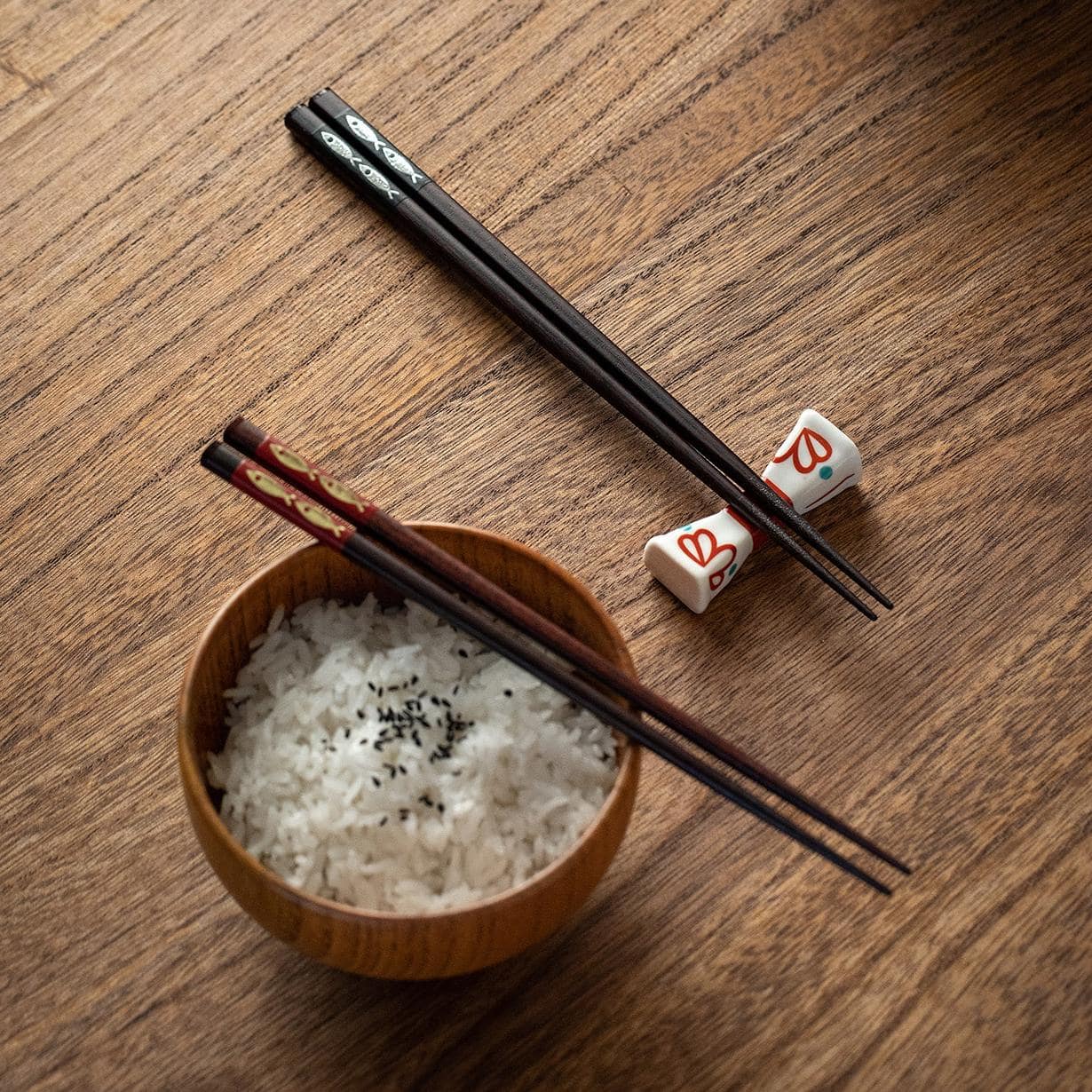 Elegant red and black chopstick set resting on ceramic plate