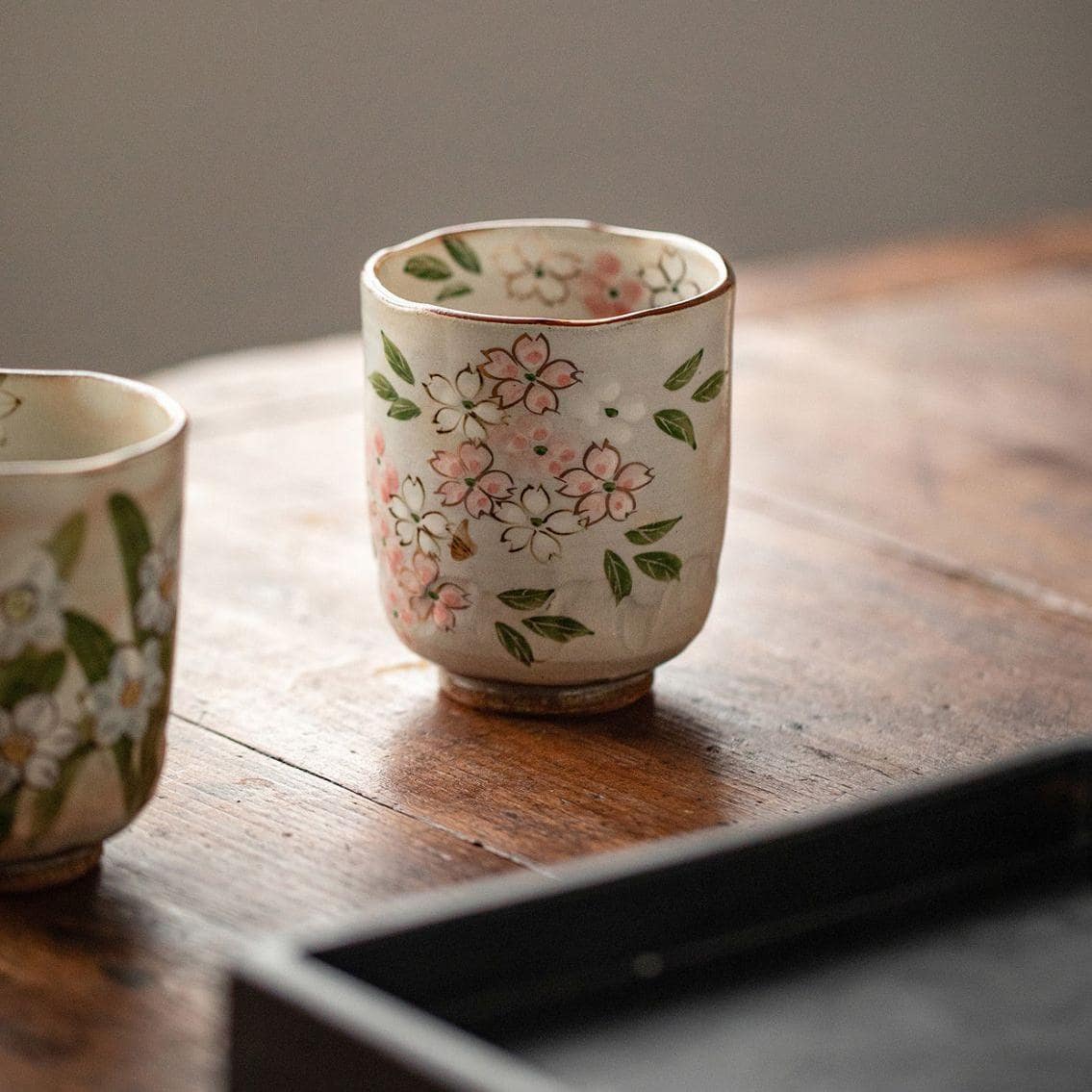 Hand-painted ceramic tea cups featuring seasonal floral designs.