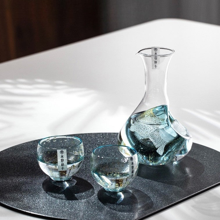 Modern glass sake set with carafe and two cups.