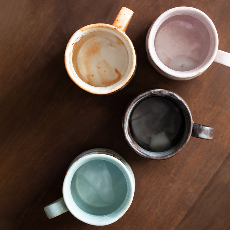 Top view of handmade ceramic mugs in assorted colors