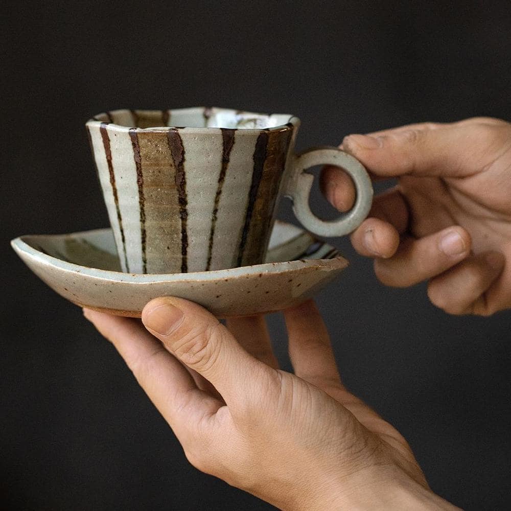 Hand-painted ceramic cup with lavender design and saucer.