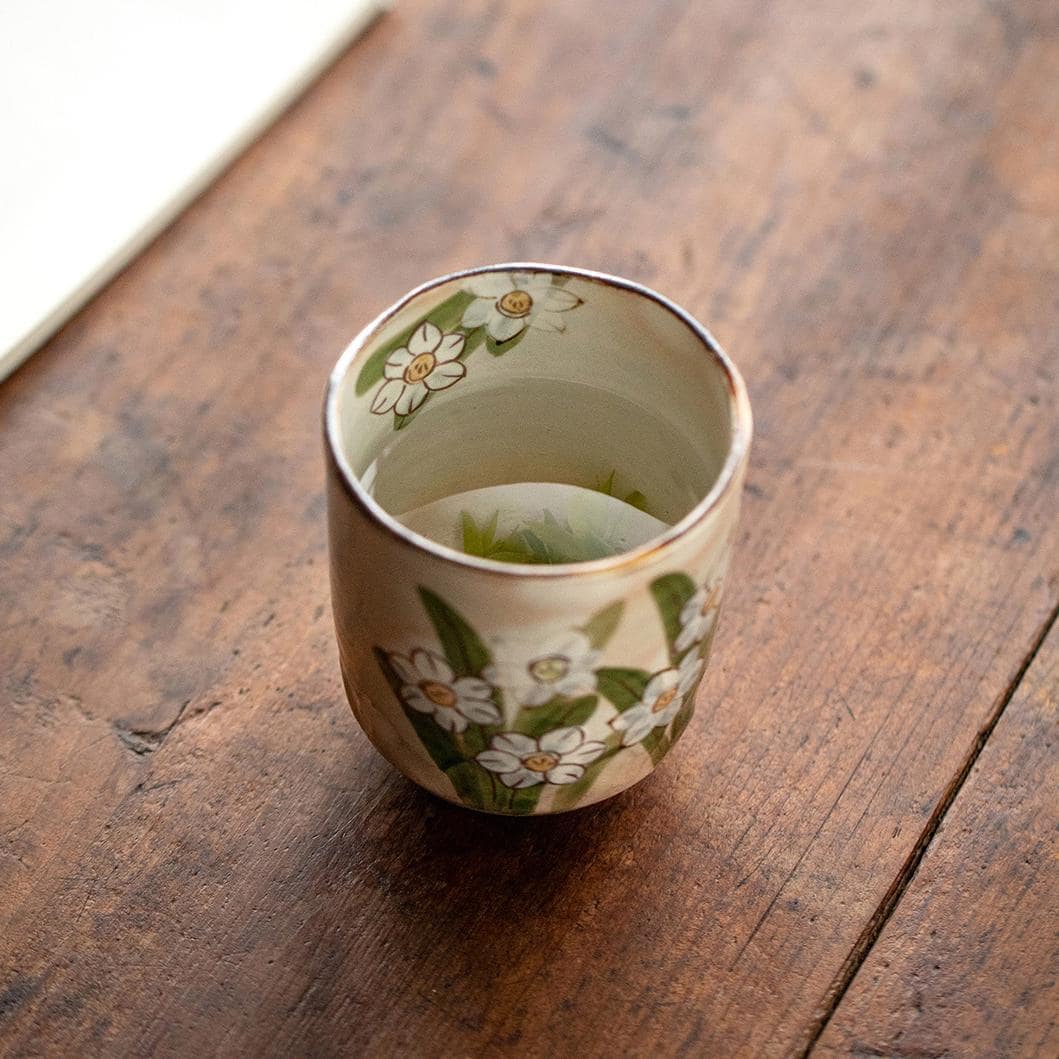 Unique hand-painted ceramic tea cup with daffodil pattern.