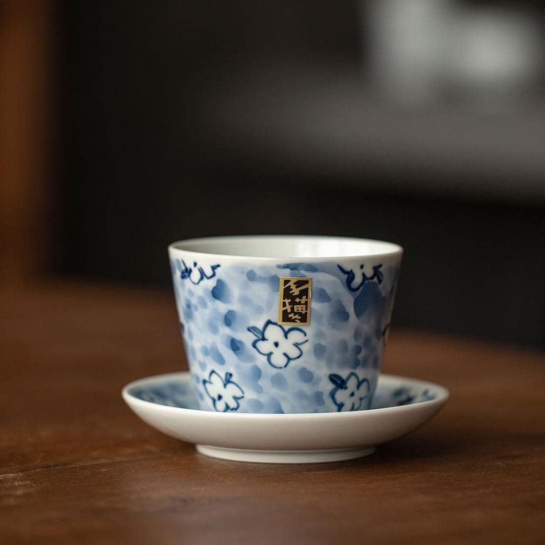 Blue floral porcelain cup with matching saucer on wooden tray