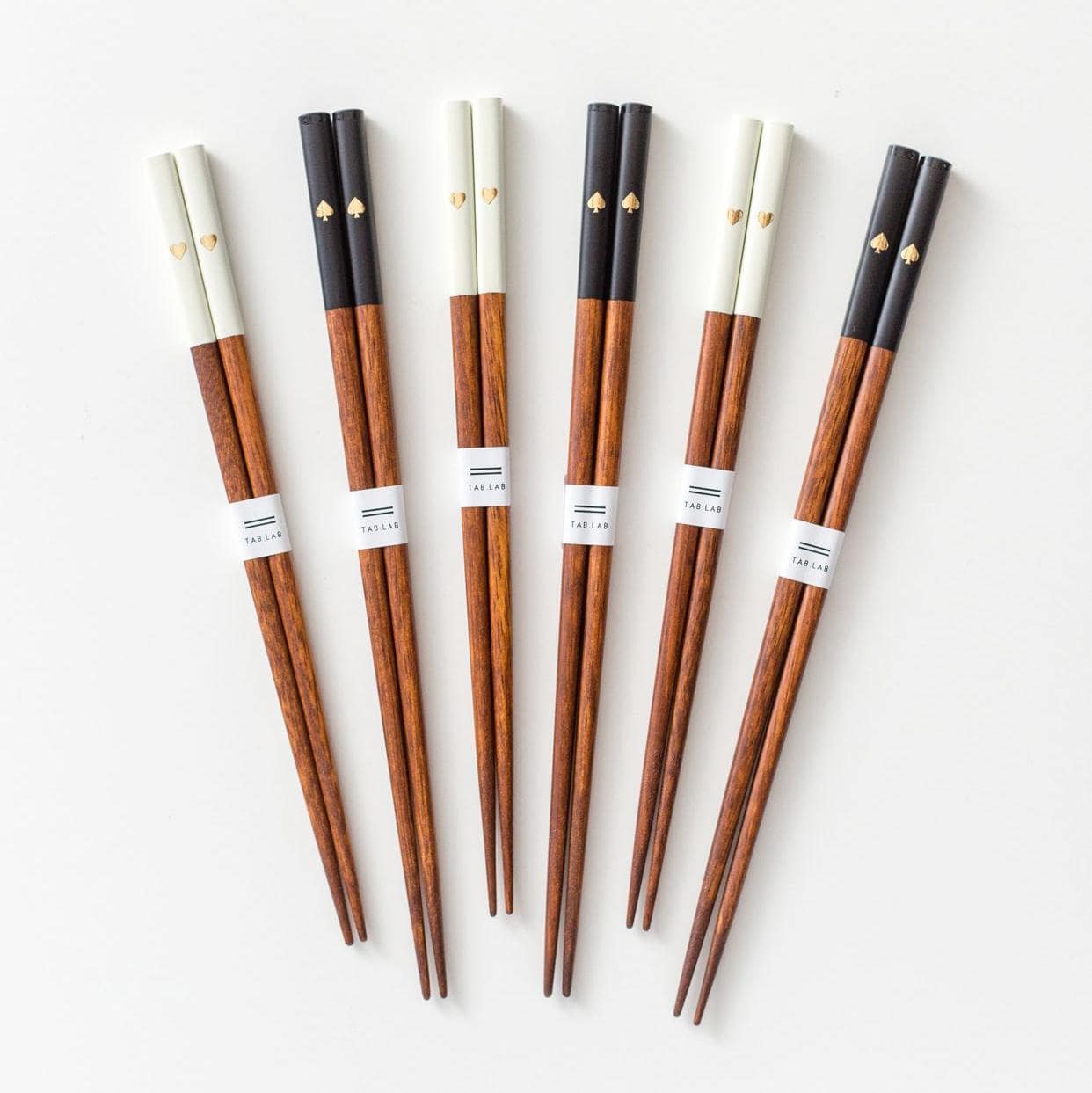 Close-up of gold-detailed chopsticks with a natural wood finish