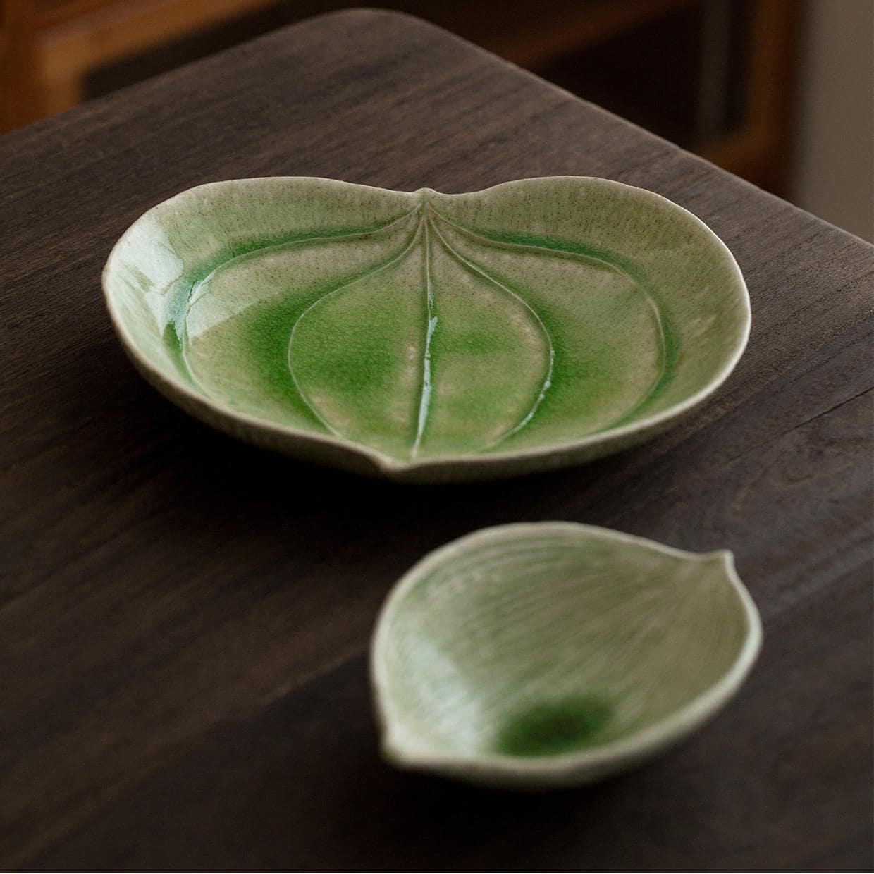 Leaf-shaped ceramic plates with green glaze and intricate texture