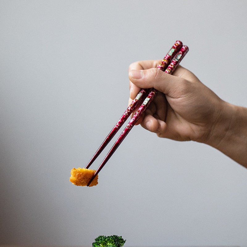 Close-up of non-slip pointed chopsticks in red and blue designs.