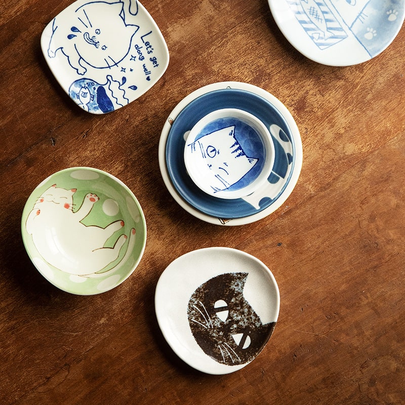 Handcrafted ceramic dipping bowl featuring a winking cat illustration