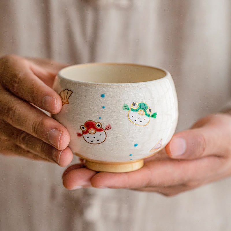 Playful ceramic cup with colorful aquatic animal illustrations.