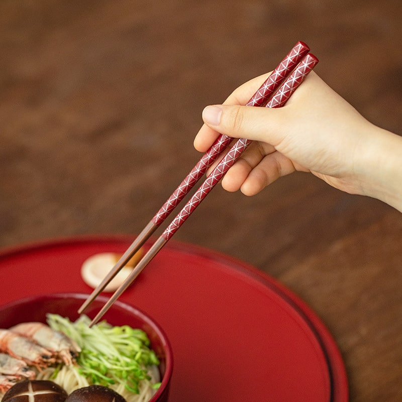 Japanese chopsticks held while dining, showcasing ergonomic design.