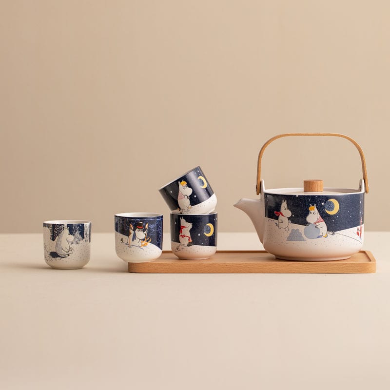 Night-sky-themed Moomin tea set with teapot and cups on a wooden tray.